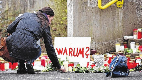 &bdquo;Warum&ldquo; ist die zentrale Frage: Eine Frau legt eine Blume am Joseph-König-Gymnasium in Haltern nieder.