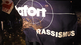 Solidaritätskundgebung für Flüchtlinge in Clausnitz       -  Und dann wieder die andere Seite: 'Tatort Rassismus'; steht auf einem Plakat, das Teilnehmer am 20.02.2016 zu einer Solidaritätskundgebung nahe der Flüchtlingsunterkunft in Clausnitz, einem Ortsteil von Rechenberg-Bienenmühle (Sachsen), mitgebracht haben.