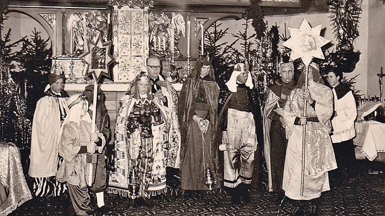 Die Sternsinger im Jahr 1963 mit Stadtpfarrer Karl Merz vor dem Hochaltar der Stadtpfarrkirche. Zwei Gruppen gab es zu dieser Zeit.