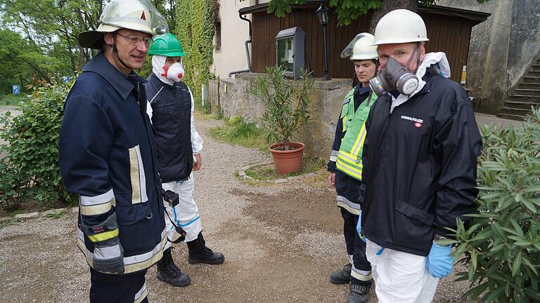 Volkachs Feuerwehrkommandant Fred Mahler (links) und sein Pressesprecher Moritz Hornung (zweiter von links) besprechen sich mit den Polizeibeamten der Kriminalpolizei, die sich auf die Suche nach dem Brandherd begaben.