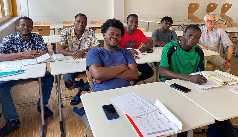 Sechs junge Männer aus Côte d'Ivoire lernen fleißig Deutsch mit Hilfe von Wörterbüchern und Notizen. Lehrer Michael Reich unterstützt sie dabei mit Erklärungen auf Deutsch und Französisch. Sechs junge Männer aus Côte d'Ivoire lernen fleißig Deutsch mit Hilfe von Wörterbüchern und Notizen. Lehrer Michael Reich unterstützt sie dabei mit Erklärungen auf Deutsch und Französisch.