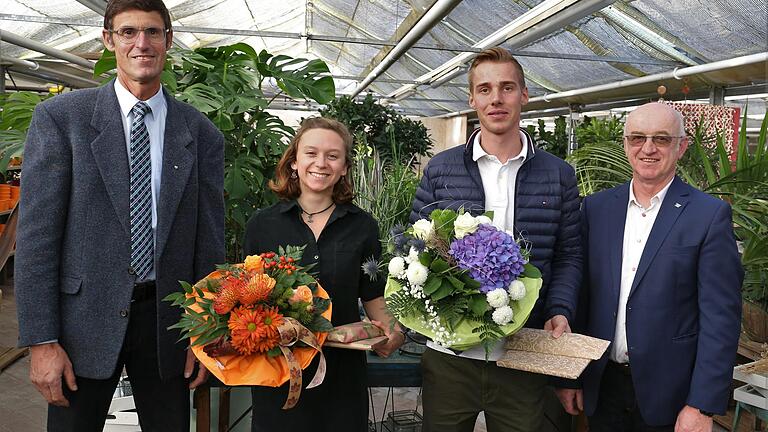 Der Unterfränkische Bezirksobermeister des Bayerischer Gärtnerei-Verbandes e.V. Friedrich Reim (rechts) und sein Stellvertreter Wilhelm Rippel gratulieren in Reims Blumenhaus in Veitshöchheim Christopher Eberth und Laura Kellner, die beide die Gärtnergehilfenprüfung 2021 mit der Note sehr gut bestanden haben.