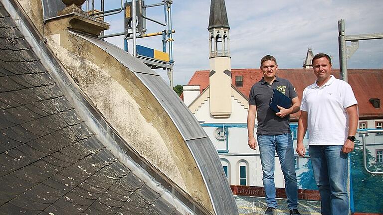 Hoch oben, auf dem Gerüst, haben die Arbeiter einen herrlichen Blick auf die  Dächer der Stadt.