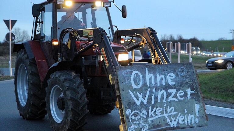 Rund 200 Landwirte und Winzer demonstrierten am Freitagabend in Volkach gegen die Spar-Pläne der Bundesregierung. Die Sternfahrt führte auch durch den Kreisverkehr beim Aldi. Rund 200 Landwirte und Winzer demonstrierten am Freitagabend in Volkach gegen die Spar-Pläne der Bundesregierung. Die Sternfahrt führte auch durch den Kreisverkehr beim Aldi.