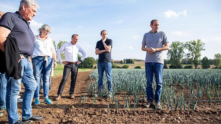 Landwirt Martin Schlereth (rechts) demonstriert dem Umweltminister (Mitte) und den Bürgermeisterinnen und Bürgermeistern (links: Konrad Schlier) wassersparende Bewässerung.&nbsp;