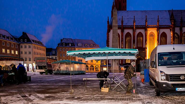 Kalt, früh, jeden Tag: Händler wie die Leinachtaler Obstbauern - hier beim Standaufbau um 7.30 Uhr auf dem Würzburger Marktplatz - verkörpern noch die alte Markttradition.