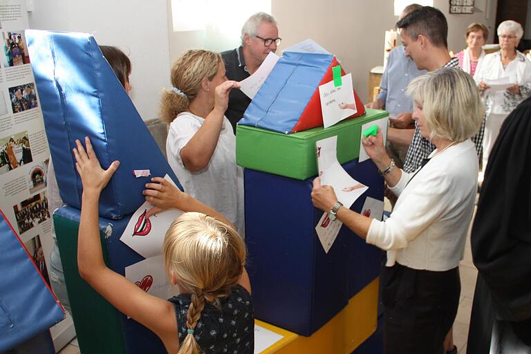 Auf Zetteln wurden die Wunschbotschaften notiert, die die Gläubigen mit ihrer Kirche verbinden. Diese Botschaften wurden dann auf den Kirchenbausteinen befestigt.