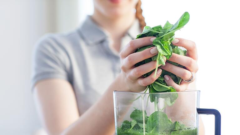 Frau bereitet am Standmixer einen Smoothie zu       -  Die Stiftung Warentest hat Mixer von klein bis groß getestet: fünf Smoothie-Maker und elf Stand- und Hochleistungsmixer.