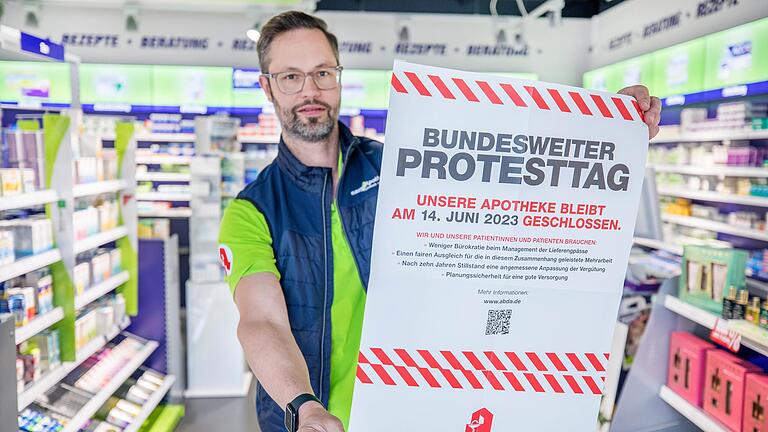 Der Apotheker&nbsp; Christian Machon hält in seiner easy Apotheke in Bad Neustadt ein Plakat zum&nbsp; Apotheken-Protesttag in den Händen. Er wird sich an dem Streik am Mittwoch, 14. Juni, beteiligen.