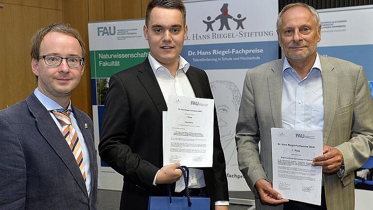 Gemeinsam mit dem jungen Forscher Tony Oehm (Mitte) freuen sich Dr. Reinhard Schneider von der FAU Erlangen (links) und Max Bauer (Schulleiter am Regiomontanus-Gymnasium in Haßfurt) über die erfolgreiche Teilnahme im Fachbereich Physik.