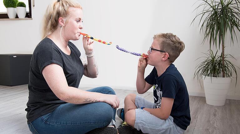 Franziska Hofstetter trainiert mit einem Kind die Lippen- und Wangenkraft. Franziska Hofstetter trainiert mit einem Kind die Lippen- und Wangenkraft.