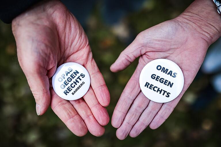 Unter anderem mit Ansteckbuttons machen die 'Omas gegen Rechts' auf sich aufmerksam. Auch 'Opas gegen Rechts' sind bei der Initiative inzwischen aktiv. Unter anderem mit Ansteckbuttons machen die 'Omas gegen Rechts' auf sich aufmerksam. Auch 'Opas gegen Rechts' sind bei der Initiative inzwischen aktiv.