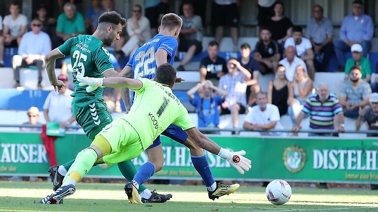 Shaban Rugovaj (links) vom TSV Großbardorf kommt vor Torhüter Andre Koob und Nicolas Reinhart vom FV 04 Würzburg zum Abschluss. Die Würzburger verloren ihr Heimspiel gegen Großbardorf, die auf der Sepp-Endres-Sportanlage ihre ersten Auswärtspunkt in dieser Saison holten.