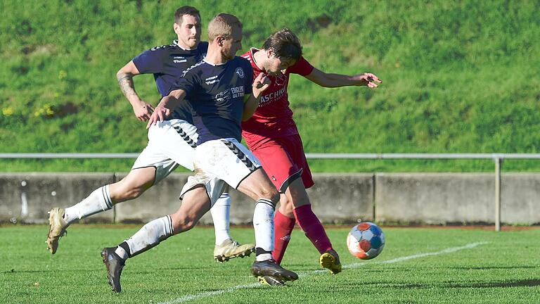 Lucas Gensler (hinten) und Nico Büttner (Mitte) vom TSV/DJK Wülfershausen können Alexander Sarwanidi (rechts) nicht am Torschuss hindern. Sarwanidi erzielte zwei Tore für den TSV Bad Königshofen.