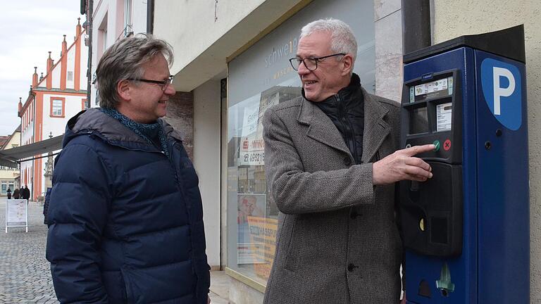 Bürgermeister Günther Werner (rechts) und Harald Bauer von der Bauverwaltung stehen an einem Parkscheinautomaten in der Haßfurter Hauptstraße. Noch spuckt er keine kostenlose Tickets für Kurzparker aus. Doch bis Freitag muss er umprogrammiert sein.