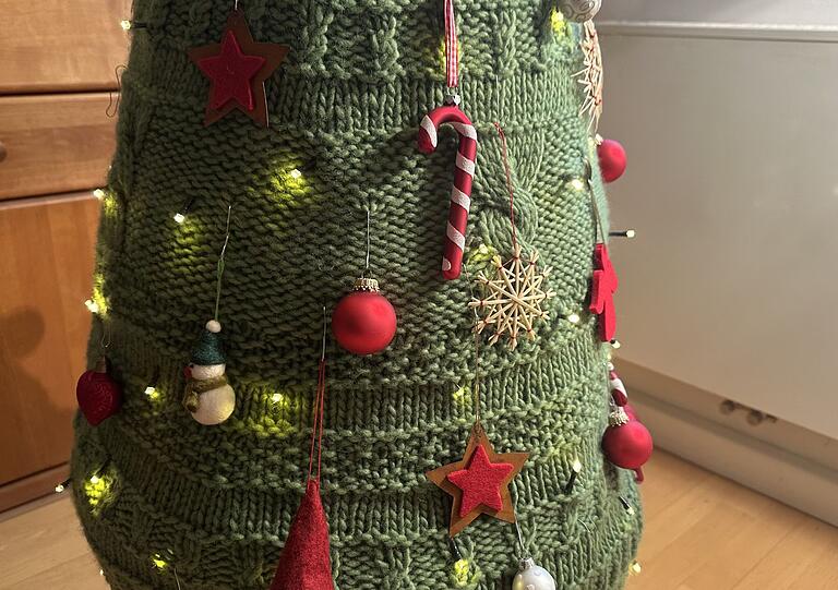 Mit Weihnachtsdeko bestückt und durch die integrierte Lichterkette strahlend ähnelt der Baum aus Wolle einem echten Weihnachtsbaum. Mit Weihnachtsdeko bestückt und durch die integrierte Lichterkette strahlend ähnelt der Baum aus Wolle einem echten Weihnachtsbaum.