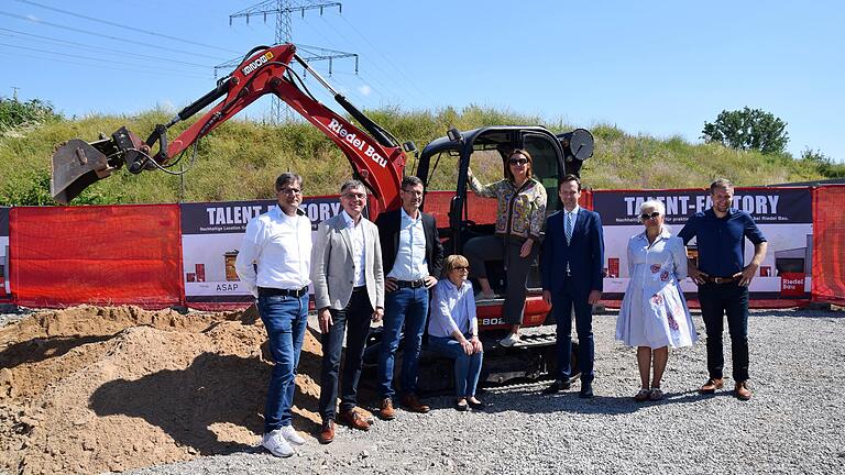 Zum Projektstart der 'Talent Factory' bei Riedel Bau, der nachhaltigen Lehrwerkstatt,&nbsp; waren dabei (von links): Martin Schlereth (Leiter Personalentwicklung Riedel Bau), Bergrheinfelds Bürgermeister Ulrich Werner, Stephan Kranig (Vorstand Riedel Bau), Mirmi Riedel (sitzend) und Stefanie Riedel, Landrat Florian Töpper, Sorya Lippert&nbsp; (Zweite Bürgermeisterin Stadt Schweinfurt) und Sven Rückert (Technischer Leiter Schlüsselfertigbau Riedel).