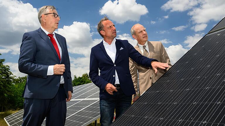 Bayerns Umweltminister Thorsten Glauber (Mitte) lässt sich von den beiden CAE-Vorständen Hans-Peter Ebert (links) und Jürgen Hartmann (rechts) neuartige Kombi-Module für Photovoltaik und Solarthermie erklären. Bayerns Umweltminister Thorsten Glauber (Mitte) lässt sich von den beiden CAE-Vorständen Hans-Peter Ebert (links) und Jürgen Hartmann (rechts) neuartige Kombi-Module für Photovoltaik und Solarthermie erklären. 