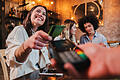 Happy young woman paying bill with a contactless credit card in a restaurant. Female smiling holding a creditcard and giving a payment transaction to the cashier.       -  Der schwarze Streifen auf der Karte ist magnetisch. Darauf sind eine Menge Informationen gespeichert.