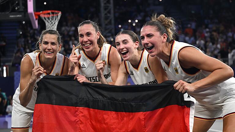 Paris 2024 - Basketball 3x3       -  Feiern mit der Fahne: Die 3x3-Basketballerinnen.