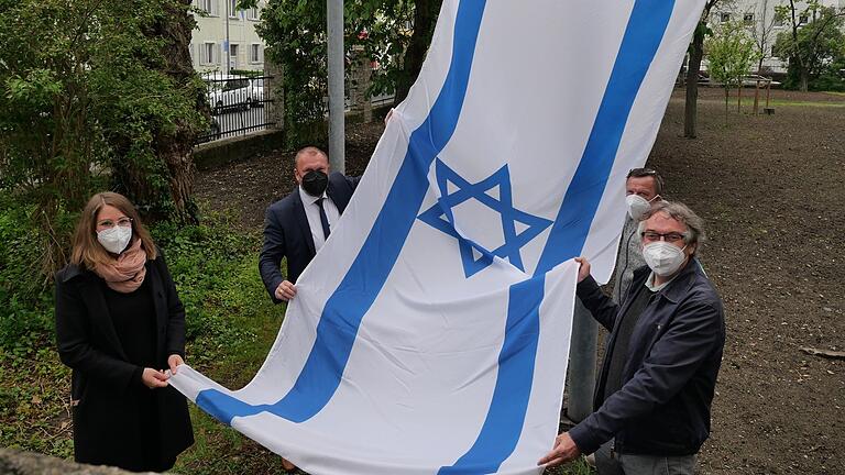 Sie sollte auch eine Mahnung für Frieden sein - nun wurde sie mutwillig zerstört: die israelische Flagge am Landratsamt Würzburg. Landrat Thomas Eberth (2.v.l.), Klaus Rostek (r.), Kathrin Jungmann (l.) und Hausmeister Roland Lorenz, hatten sie am Mittwoch anlässlich des Jahrestags der Aufnahme von diplomatischen Beziehungen zwischen Deutschland und Israel gehisst. Sie sollte auch eine Mahnung für Frieden sein - nun wurde sie mutwillig zerstört: die israelische Flagge am Landratsamt Würzburg. Landrat Thomas Eberth (2.v.l.), Klaus Rostek (r.), Kathrin Jungmann (l.) und Hausmeister Roland Lorenz, hatten sie am Mittwoch anlässlich des Jahrestags der Aufnahme von diplomatischen Beziehungen zwischen Deutschland und Israel gehisst.