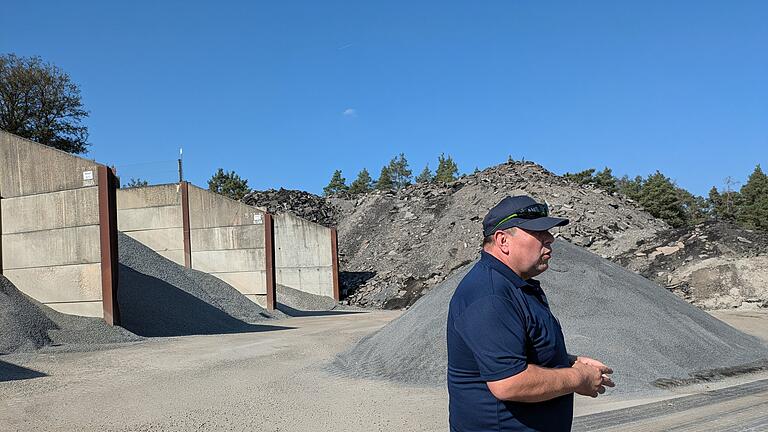 Hinter Michael Erhard ist Kies aus Basalt und Teile von Straßen als unverarbeitetes Recyclingmaterial gelagert.       -  Hinter Michael Erhard ist Kies aus Basalt und Teile von Straßen als unverarbeitetes Recyclingmaterial gelagert.