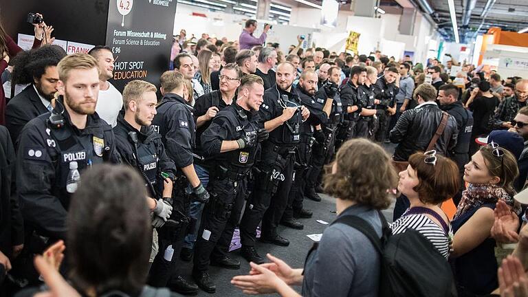 Buchmesse Frankfurt - Protest gegen Rechts       -  Ein eher ungewöhnliches Bild für die Buchmesse: Polizisten bilden eine Kette, während Demonstranten am Samstag die Fortsetzung einer Veranstaltung eines rechten Verlages verhindern.