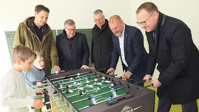 Beim Kickerturnier im neuen Kinderhaus treten zwei kleine Sonderhöfer gegen (von rechts) den Gaukönigshöfer Bürgermeister Johannes Menth und Landrat Thomas Eberth an. Das Spiel verfolgen (hinten von links) Landtagsabgeordneter Björn Jungbauer,&nbsp; Landtagsabgeordneter Volkmar Halbleib und Sonderhofens Bürgermeister Heribert Neckermann.