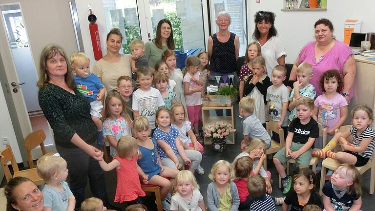 Helga Dietz umringt von den Kindern und den Kolleginnen im Kinderhaus (von links) Nathalie Büttner, Astrid Hummel-Schmidt, Annalena Lurz, Gabi Mock, Helga Dietz selbst, Ingrid Wirsing und Manuela Mendrella-Louis.