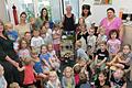 Helga Dietz umringt von den Kindern und den Kolleginnen im Kinderhaus (von links) Nathalie Büttner, Astrid Hummel-Schmidt, Annalena Lurz, Gabi Mock, Helga Dietz selbst, Ingrid Wirsing und Manuela Mendrella-Louis.