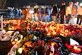 Trauernde Schüler und Einwohner des Ortes Winnenden stehen am 12. März 2009 nahe der Albertville-Realschule (im Hintergrund) vor zahllosen Blumen und Grablichtern.