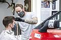 Sicheres Arbeiten dank Schrottteilen: Eine Autotüre trennt die Arbeitsplätze der Friseure des 'Booder' in Haßfurt. Marco Maas (rechts) hat den ersten Arbeitstag unter erschwerten Bedingungen hinter sich gebracht.