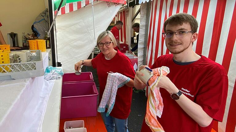 Renate Juks vom Frauenbund und Marco Jörg vom Liederkranz schwingen am Spülmobil die Geschirrtücher.