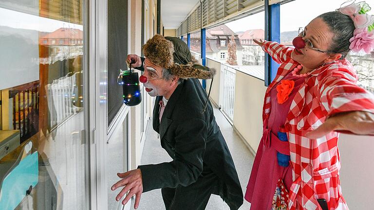 Die Klinikclowns JoJo und Machnix tanzen zu Weihnachtsmusik auf dem Balkon der Kinderklinik des Würzburger Uniklinikums.
