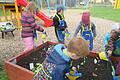 Mit Eifer bei der Sache: Die Kinder beim Bepflanzen des Hochbeetes.