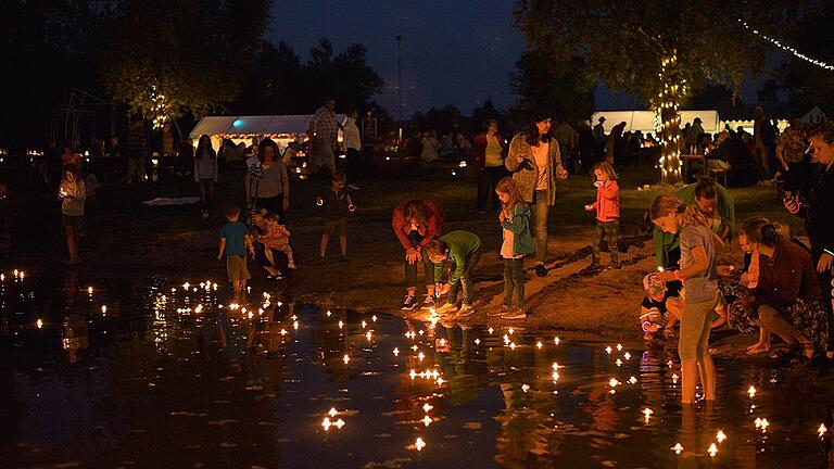 Höhepunkt der Lichternacht: Viele Schwimmkerzen werden von Kindern zu Wasser gelassen.