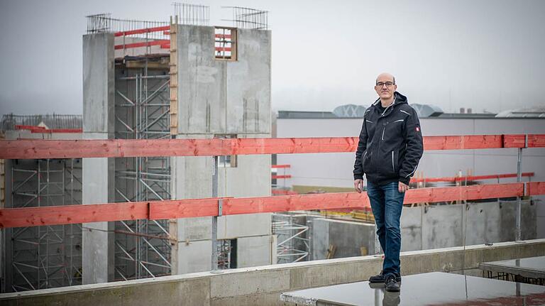 Kommandant Bernhard Nees bei der ersten offiziellen Führung durch den Feuerwehrneubau. Im Hintergrund ist der Übungsturm mit angebautem Salzsilo der Stadt Marktheidenfeld zu erkennen.