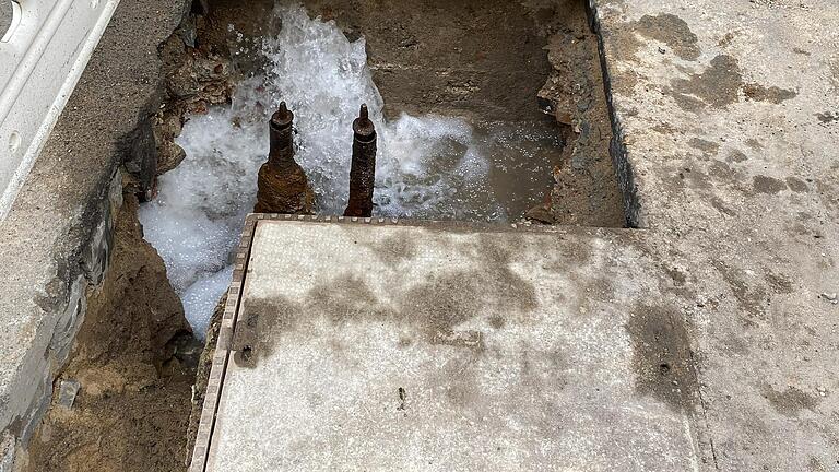 Wasserohrbruch in der Franziskanergasse in Würzburg am Mittwochnachmittag: In einem Loch im Boden sprudelt das Wasser.