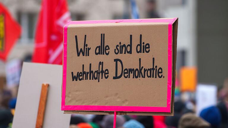 Demonstrationen gegen Rechtextremismus       -  Ein Plakat „Wir alle sind die wehrhafte Demokratie“ wird auf einer Kundgebung gegen Rechtsextremismus gezeigt. Für Bad Kissingen ist eine ähnliche Demo für Sonntag, 4. Februar, angemeldet