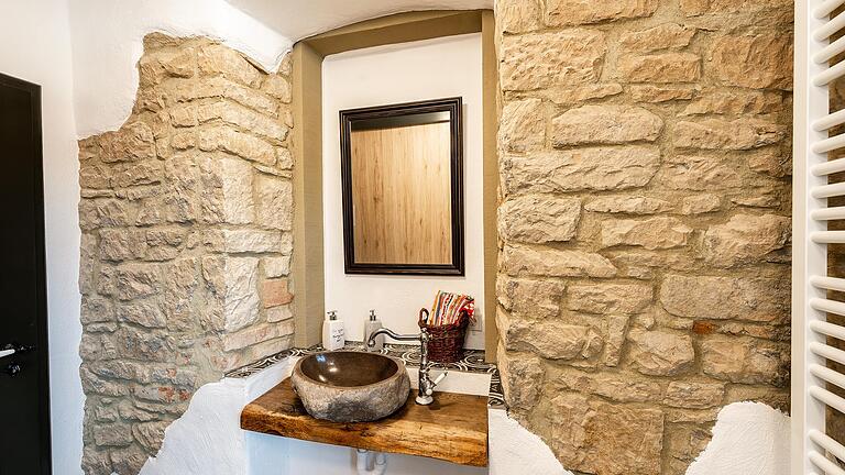 In der Toilette ist die frühere Außenwand des Sandsteinhauses sichtbar gemacht. In der Toilette ist die frühere Außenwand des Sandsteinhauses sichtbar gemacht.