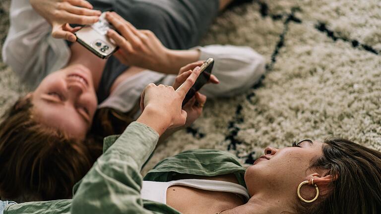 Zwei junge Fauen mit ihren Smartphones - Kurze Clips in den sozialen Netzwerken aktivieren unser Belohnungszentrum schneller als Bücher oder Brettspiele. Dabei braucht unser Nervensystem Bildschirm-Pausen, um sich zu erholen. Zwei junge Fauen mit ihren Smartphones - Kurze Clips in den sozialen Netzwerken aktivieren unser Belohnungszentrum schneller als Bücher oder Brettspiele. Dabei braucht unser Nervensystem Bildschirm-Pausen, um sich zu erholen.