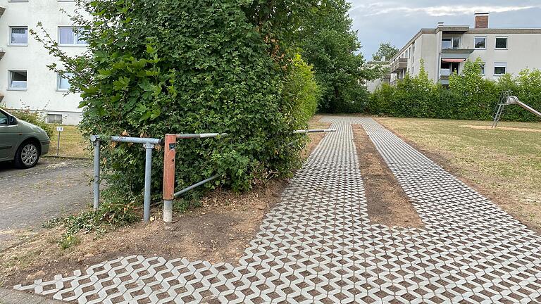 Auf dem Gelände des Spielplatzes 'An den Birken' in Marktheidenfeld wurde eine Feuerwehrzufahrt aus Beton-Rasengitter-Steinen für das Nachbarhaus (links) geschaffen. Damit sind nicht alle Anwohnerinnen und Anwohner einverstanden.