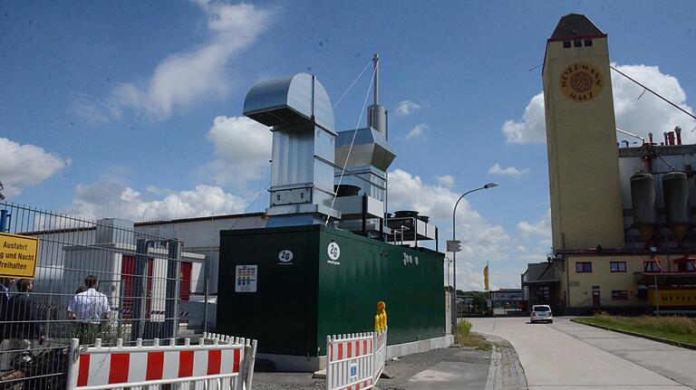 In einem grünen Container steht das neue Wasserstoff-Blockheizkraftwerk im Haßfurter Hafen. Zwar ist die Anlage im Inneren recht laut, doch sobald die Türen einmal zu sind, dringt davon kaum etwas nach außen, so dass die Geräusche noch von der nahegelegenen Mälzerei übertönt werden. In einem grünen Container steht das neue Wasserstoff-Blockheizkraftwerk im Haßfurter Hafen. Zwar ist die Anlage im Inneren recht laut, doch sobald die Türen einmal zu sind, dringt davon kaum etwas nach außen, so dass die Geräusche noch von der nahegelegenen Mälzerei übertönt werden.