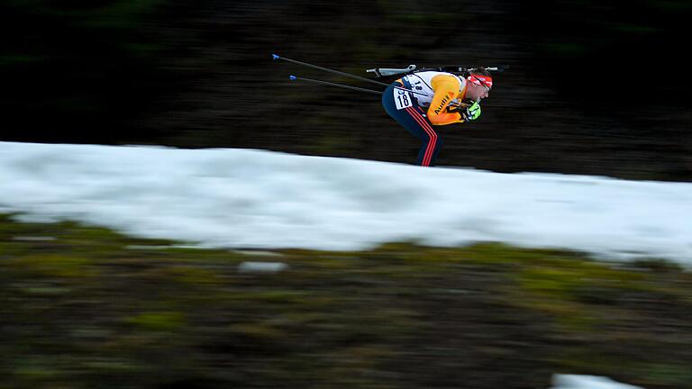 Oben der deutsche Biathlet Johannes Kühn, darunter ein wenig Schnee, ansonsten Grau, Braun und Grün: Der Oberhofer Biathlon-Weltcup litt unter Schneemangel.