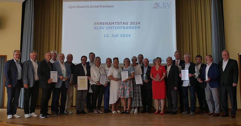 Alle Geehrten mit den Laudatoren. Von links: Klaus Greier (BLSV Bezirksvorsitzender), Josef Scheller (Kreisvorsitzender Kitzingen), Kurt Semmler (Kreis Kitzingen), Helmar Scheuring (Kreis Rhön-Grabfeld), Helmut Radler (Kreisvorsitzender Würzburg-Stadt), Heinz Gräf (Würzburg-Stadt), Klaus Rehberger (Raymund-Schmitt-Preis), Ingo Göllner (Kreisvorsitzender Schweinfurt), Sigrid Herder (Kreis Schweinfurt), Ludwig Stegmann (Kreis Aschaffenburg), Alexandra Krohnen (stv. Bezirksvorsitzende), Irma Sell (Kreis Bad Kissingen), Karin Stumpf (Kreis Würzburg -Land), Thomas Schiebel (Bezirkstagsvizepräsident), Burkard Losert (Kreisvorsitzender Würzburg-Land), Adolf Zerr (Kreisvorsitzender Miltenberg), Brigitte Kohl (Kreis Miltenberg), Dr. Kurt Vogel (Ehrenkreisvorsitzender Schweinfurt), Berthold Rüth (Raymund-Schmitt-Preis), Horst Ott (Kreis Main-Spessart) Theo Anderlohr (Kreisvorsitzender Main-Spessart), Edwin Metzler (stv. Kreisvorsitzender Bad Kissingen), Karl-Heinz Hübner (stv. Bezirksvorsitzender) Alle Geehrten mit den Laudatoren. Von links: Klaus Greier (BLSV Bezirksvorsitzender), Josef Scheller (Kreisvorsitzender Kitzingen), Kurt Semmler (Kreis Kitzingen), Helmar Scheuring (Kreis Rhön-Grabfeld), Helmut Radler (Kreisvorsitzender Würzburg-Stadt), Heinz Gräf (Würzburg-Stadt), Klaus Rehberger (Raymund-Schmitt-Preis), Ingo Göllner (Kreisvorsitzender Schweinfurt), Sigrid Herder (Kreis Schweinfurt), Ludwig Stegmann (Kreis Aschaffenburg), Alexandra Krohnen (stv. Bezirksvorsitzende), Irma Sell (Kreis Bad Kissingen), Karin Stumpf (Kreis Würzburg -Land), Thomas Schiebel (Bezirkstagsvizepräsident), Burkard Losert (Kreisvorsitzender Würzburg-Land), Adolf Zerr (Kreisvorsitzender Miltenberg), Brigitte Kohl (Kreis Miltenberg), Dr. Kurt Vogel (Ehrenkreisvorsitzender Schweinfurt), Berthold Rüth (Raymund-Schmitt-Preis), Horst Ott (Kreis Main-Spessart) Theo Anderlohr (Kreisvorsitzender Main-Spessart), Edwin Metzler (stv. Kreisvorsitzender Bad Kissingen), Karl-Heinz Hübner (stv. Bezirksvorsitzender)