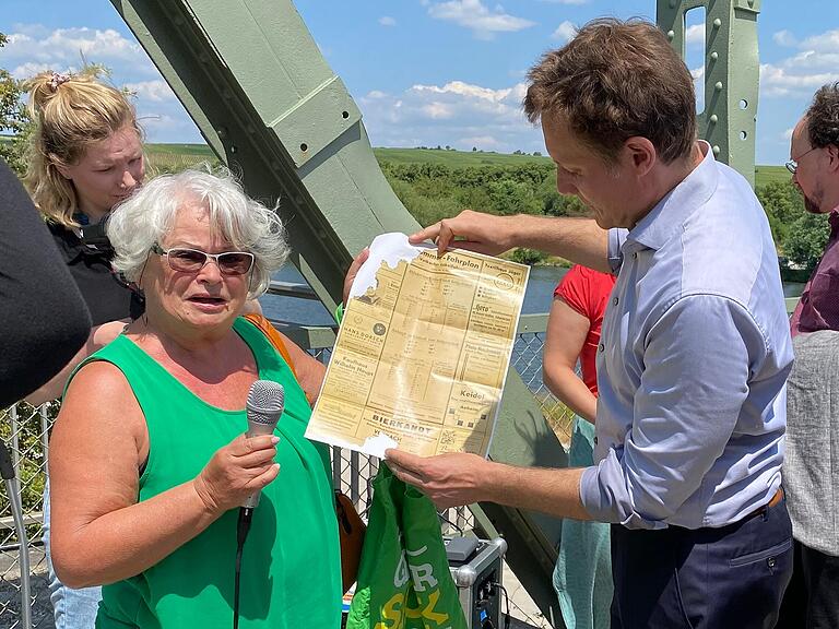 Regina Hetterich aus Volkach präsentierte Grünen-Fraktionschef Ludwig Hartmann einen historischen Fahrplan der Mainschleifenbahn.