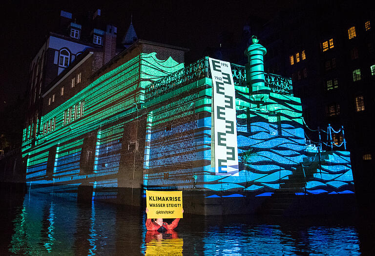 Plakative Aktion: Greenpeace-Aktivisten projizieren in der Speicherstadt in Hamburg die mögliche Höhe des Wasserstands zum Ende des Jahrhunderts auf das Wasserschloss.