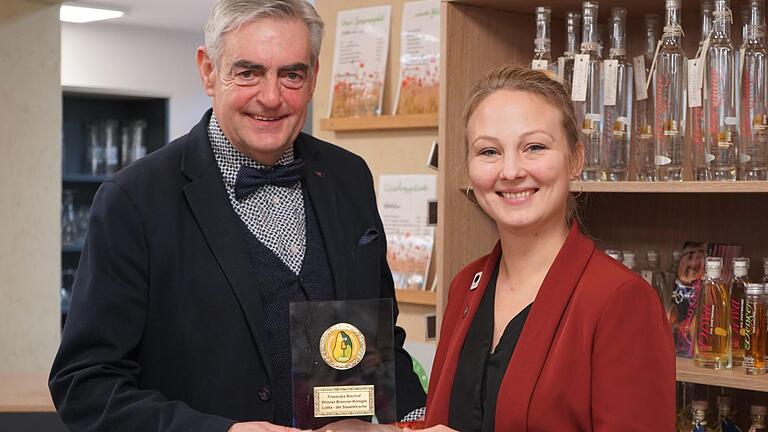 Matthias Weller ist einer der Hauptorganisatoren des 1. Rhöner Schinken- und Destillationsmarkt in Rasdorf. Er überreicht im Biosphärenzentrum Rhön Haus der Schwarzen Berge die Auszeichnung an die Brenner-Königin Franziska Bischof aus Wartmannsroth. Foto: Kathrin Kupka-Hahn       -  Matthias Weller ist einer der Hauptorganisatoren des 1. Rhöner Schinken- und Destillationsmarkt in Rasdorf. Er überreicht im Biosphärenzentrum Rhön Haus der Schwarzen Berge die Auszeichnung an die Brenner-Königin Franziska Bischof aus Wartmannsroth. Foto: Kathrin Kupka-Hahn