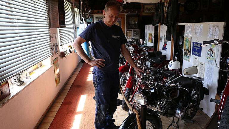 Christian Zimmermann bei einer Reihe historischer Motorräder.