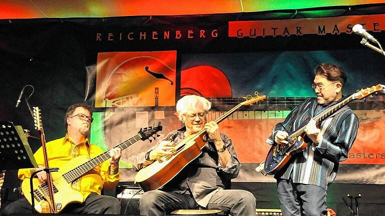 8. Guitar Masters: Die Weltelite in Reichenberg       -  (abra)   Seit acht Jahren bereitet die Weltelite der Jazz-, Fingerstyle- und Bossa-Gitarre dem Publikum in der Reichenberger Wolffskeelhalle unvergessliche Konzerterlebnisse. Und inzwischen ist die Bindung zwischen Musikern und Publikum so eng, dass die Gitarrenmeister, selbst wenn sie im Deutschen ungeübt sind, doch wenigstens ein paar Sätze in Landessprache an ihre Zuhörer richten. Allen voran Jazzrock-Legende Larry Coryell (Mitte), der als Stammgast fast an allen Guitar Masters teilgenommen hat. Der Texaner schätzt die Gastfreundschaft des Kulturvereins rund um Reinhold Deinhardt, der in Reichenberg etwas für die Gitarristen-Szene Einmaliges geschaffen hat. Wo sonst in Deutschland ist es möglich, die edelsten Protagonisten ihrer Stilrichtung an einem Abend zu erleben? Am Samstag kamen neben Coryell auch der Japaner Kazumi Watanabe (rechts) und der Sizilianer Francesco Buzzurro in den Würzburger Vorort. Mehr noch: Das dänische Acoustic Guitars Trio, das sich vor zehn Jahren aufgelöst hatte, hat sich auf Bitten des Veranstalters nur fürs Guitar Masters erneut zusammengefunden. Ein eindrucksvoller Beleg für die Sogwirkung dieses Festivals auf die Meistergitarristen. Selbst die Begleitmusiker gehören zu den Meistern ihres Fachs: der amerikanische Bassist Dave King (links), der britische Schlagzeuger Asaf Sirkis und der kubanische Percussionist Eliel Lazo. Vom Publikum fordert die hohe Gitarrenkunst in unterschiedlichen Stilen, Spielweisen und Zusammensetzungen höchste Konzentration. Die Zuhörer dankten es jedes Mal mit begeistertem Applaus. Vielleicht ein weiterer Grund dafür, dass die Weltelite so gerne in Reichenberg auftritt. Lesen Sie die Besprechung des Konzerts im Kulturteil. Mehr Bilder vom Konzert im Internet unter www.wuerzburg-land@mainpost.de